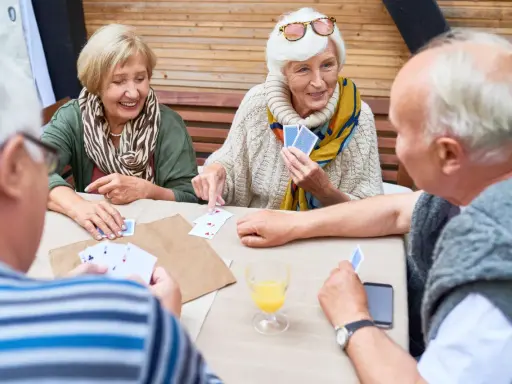 Seniorzy grają w karty, ćwicząc umysł i poprawiając pamięć.
