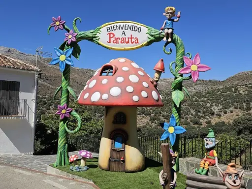 Bienvenido a Parauta, inicio de la ruta del bosque encantado. Un duende saluda desde un arco con flores y un hongo mágico.