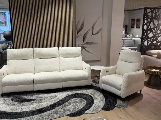 Sofá blanco de tres plazas y butaca a juego, perfectos para combinar sofá y butaca en tu salón. Alfombra moderna y cuadro decorativo.