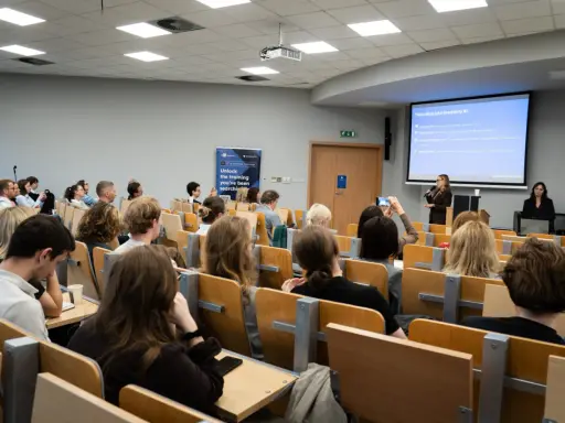 Wykład o specjalizacji BI, gdzie można zdobyć wiedzę potrzebną do zrobienia magisterki w rok. Studenci słuchają prezentacji.