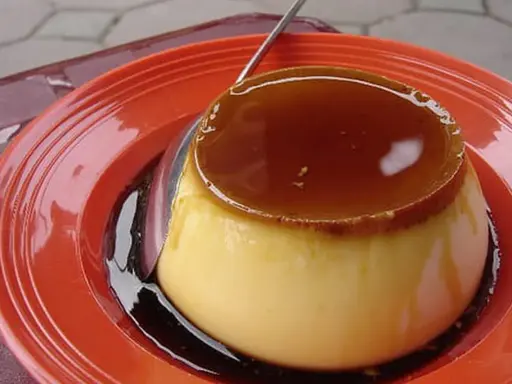 Un délicieux crème caramel, tout juste sorti du four, prêt à être dégusté. Sa texture onctueuse et son caramel doré invitent à la gourmandise.
