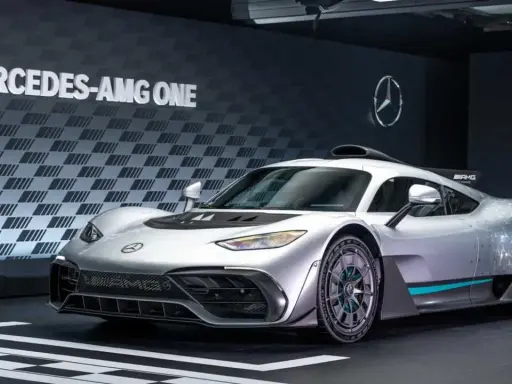 Silberner Mercedes-AMG ONE mit auffälligem Design und dem Schriftzug "MERCEDES-AMG ONE" im Hintergrund.