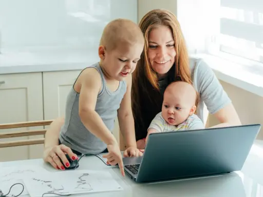 Mama z dwójką dzieci przy laptopie, starszak pokazuje coś na ekranie. To ich wspólny artystyczny projekt, może nawet z elementami art 188 kp.