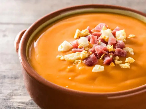 Un cuenco de salmorejo, la deliciosa comida típica de Córdoba, adornado con trocitos de huevo duro y jamón serrano.