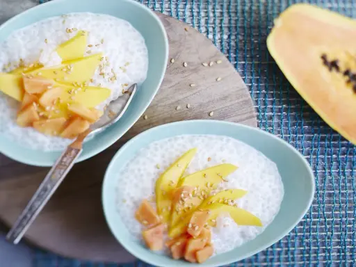 Douceur tropicale : tapioca au lait de coco, garni de mangue et papaye, parsemé de graines de sésame.