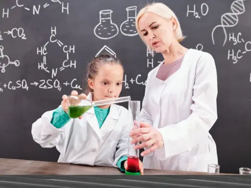 Nauczycielka chemii z pasją pokazuje uczennicy eksperyment. Ciekawe, ile zarabia nauczyciel chemii za taką pracę!