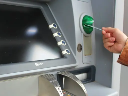 Mano insertando una tarjeta N26 extranjero en un cajero automático.
