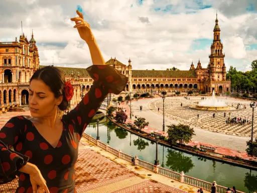 Flamenco-Tänzerin vor der Plaza de España in Sevilla, Spanien. Ein Wasserfall sprudelt im Hintergrund.