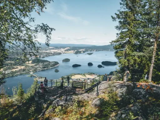 Widok z punktu widokowego w **Oslo park** na spokojną zatokę z licznymi wysepkami i miasteczkiem w oddali.