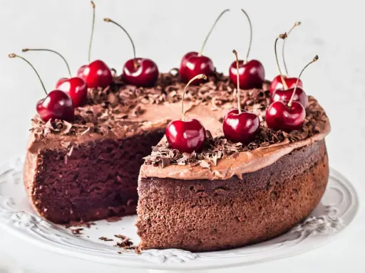 Gâteau chocolat cerise, riche et moelleux, décoré de cerises fraîches et de copeaux de chocolat. Un délice gourmand.