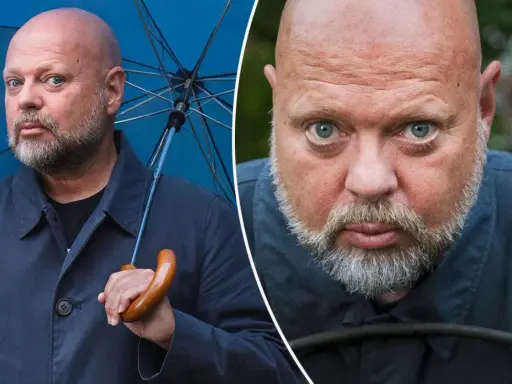 Peter LeMarc, med sitt karakteristiska skalliga huvud och skägg, håller ett blått paraply. En närbild visar hans intensiva blick.