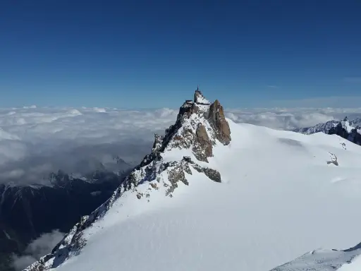 Szczyt Aiguille du Midi w Alpach Włoskich, z widokiem na morze chmur i ośnieżone góry.