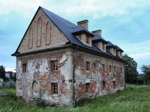Stary budynek w Bieczu, zniszczony tynk, ceglane ściany, okna z drewnianymi ramami. Jedna z bieckich atrakcji, czekająca na renowację.