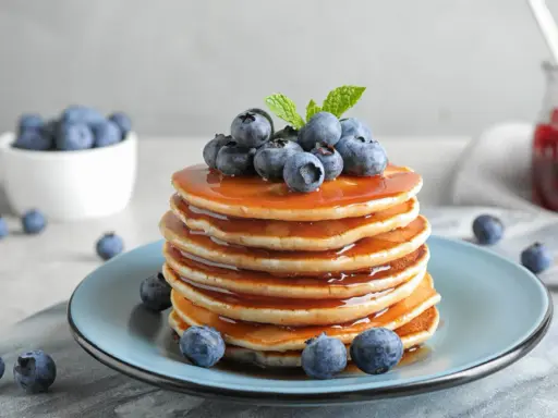 Pyszny stos naleśników z syropem i borówkami, idealny na śniadanie. Ten przepis na pancake zachwyci każdego!