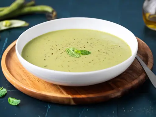 Una ciotola di cremoso purè di fave, guarnito con menta fresca e pepe nero, pronto per essere gustato.
