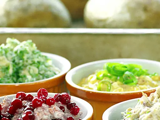 Olika skålar med bakad potatis fyllning: krusbär, gräslök och en grön fyllning.