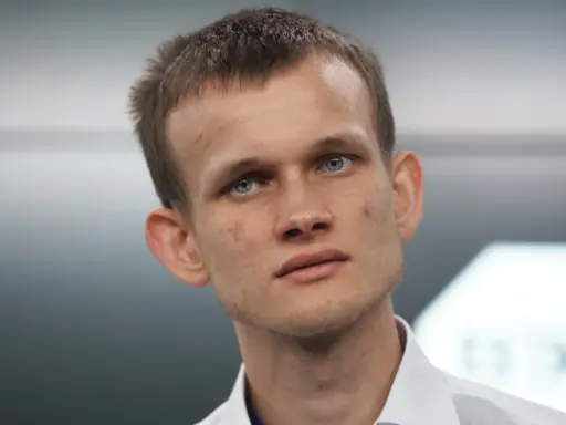 Vitalik Buterin, twórca Ethereum, z niebieskimi oczami i krótkimi włosami, w białej koszuli.