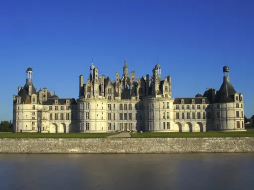 Majestatyczny zamek Chambord, perła Doliny Loary, wznosi się nad spokojną rzeką.