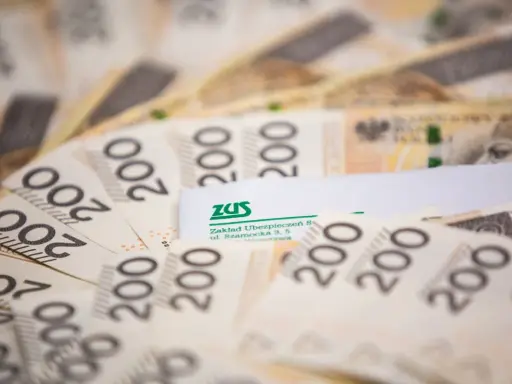 Polskie banknoty 200 zł i dokument ZUS. Ilustracja do przykładów przeliczenia emerytury kapitałowej na emeryturę powszechną.
