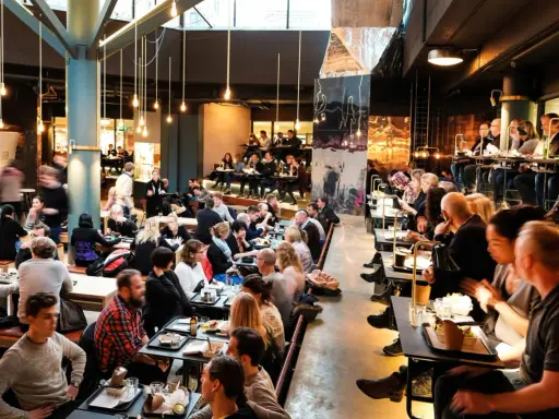 Folk äter och umgås på en livlig **Ringen food court**. Många bord är upptagna, stämningen är social och maten ser god ut.