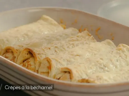 Crêpes à la béchamel gratinées, dorées et appétissantes, prêtes à être dégustées dans un plat en céramique.