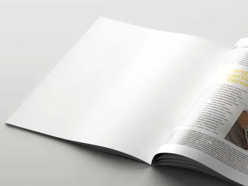 Pagina di rivista aperta, con testo "Essential vacation items" su carta satinata.