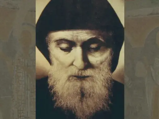 Portret brodatego mężczyzny w czapce, przypominającego świętego Szarbel, którego cuda są znane. W tle niewyraźne postacie.