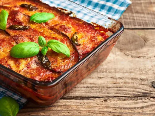 Parmigiana di melanzane in friggitrice ad aria, dorata e profumata, guarnita con basilico fresco. Un classico rivisitato per un risultato leggero e gustoso.