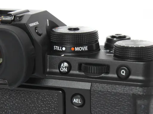 Część aparatu Fujifilm xt3 z pokrętłem wyboru trybu "STILL" i "MOVIE", przyciskiem "AF ON" i pokrętłem sterującym.