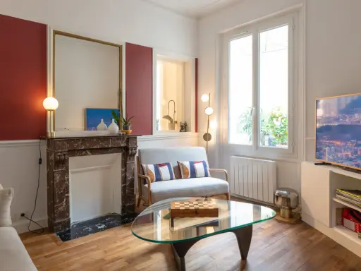 Plan salon 16m2 : cheminée en marbre, canapé gris, table basse en verre avec jeu d'échecs, fenêtre lumineuse.