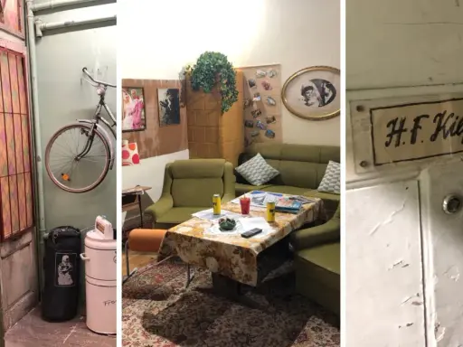 Wnętrze mieszkania Kiepskich z serialu. Widać drzwi z witrażem, rower wiszący na ścianie, kanapy i stolik kawowy.