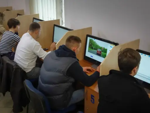 Uczestnicy kursu na prawo jazdy sprawdzają, ile błędów można zrobić na egzaminie teoretycznym, siedząc przy komputerach.