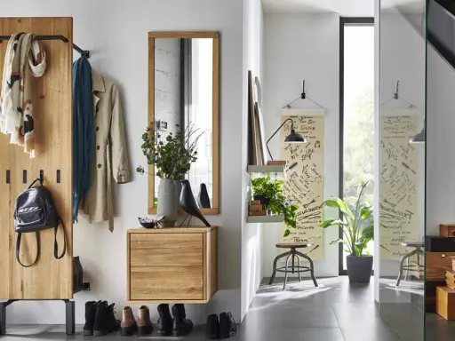Une entrée chaleureuse avec un porte-manteau en bois, des tableaux, un miroir et des boîtes de rangement. Une belle idée déco pour une entrée de maison fonctionnelle et stylée.