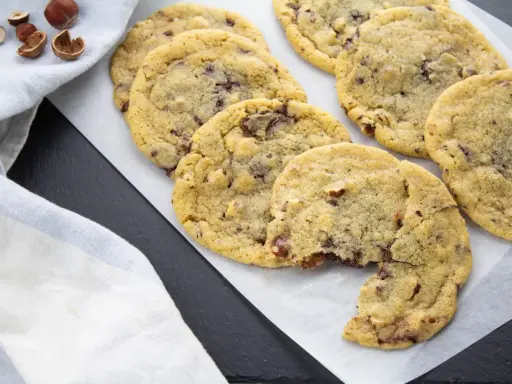 Gros plan sur des cookies aux pépites de chocolat et noisettes, dont le beurre fondu a donné une texture parfaite. Un délice !