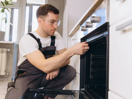 Un technicien vérifie la hauteur et l'étanchéité d'un four encastrable.
