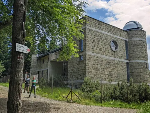 Obserwatorium astronomiczne na Lubomirze, kamienny budynek z kopułą, obok szlak turystyczny.