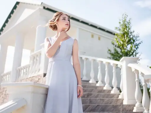 Elegancka sukienka na bierzmowanie dla dziewczyny. Jasnoszara, zwiewna kreacja z subtelnymi zdobieniami przy dekolcie, idealna na uroczystość.