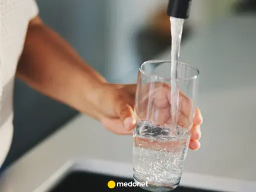 Ręka nalewa wodę do szklanki. Zastanawiasz się, kiedy skończy się woda pitna? Dbajmy o zasoby.