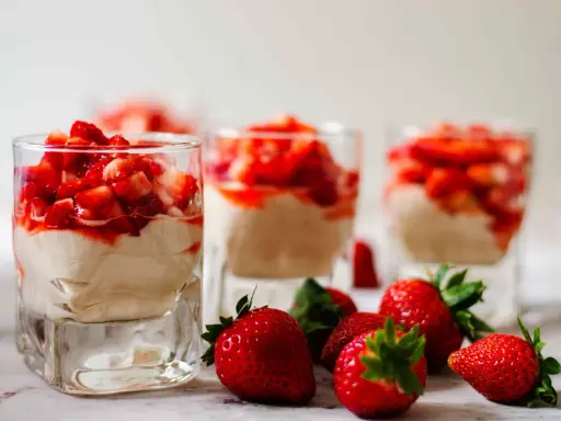 Enkel dessert med jordgubbar i glas, toppad med färska jordgubbar och en krämig fyllning. Perfekt för en sommardag.