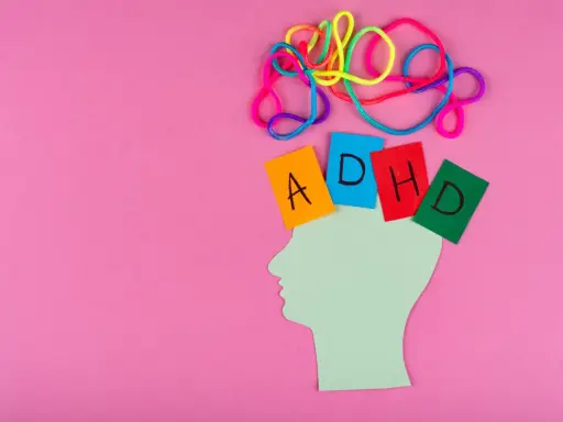 Kolorowe sznurki nad głową symbolizują chaos myśli, jak przy ADHD. Kartki z literami A, D, H, D sugerują trudności w nauce, np. dyskalkulię.