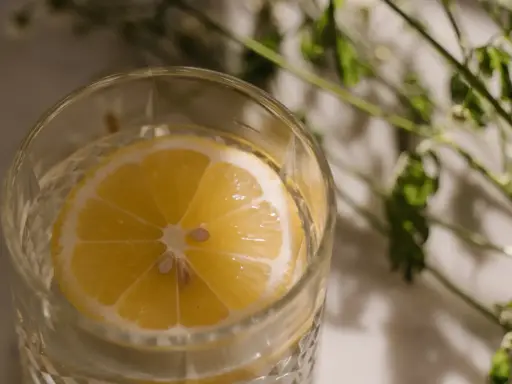 Ett glas med vatten och en citronskiva, perfekt för varma sommardagar. Enkel och uppfriskande bland sommar drinkar.