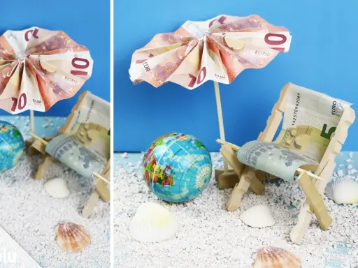 Kreative Ideen: Anker falten Geld zu einer Mini-Strandkulisse mit Liegestuhl und Sonnenschirm aus Euroscheinen.