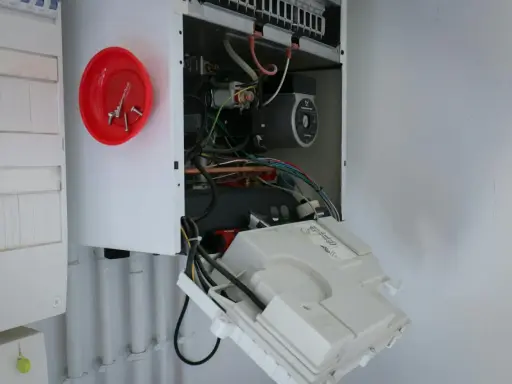 Ouvert pour l'entretien chaudière gaz obligatoire, on voit le circuit électrique et la pompe.
