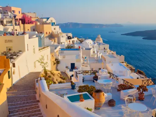 Piękne białe domy na Santorini, idealna pogoda na wrzesień w Grecji. Widok na błękitne morze i kalderę.