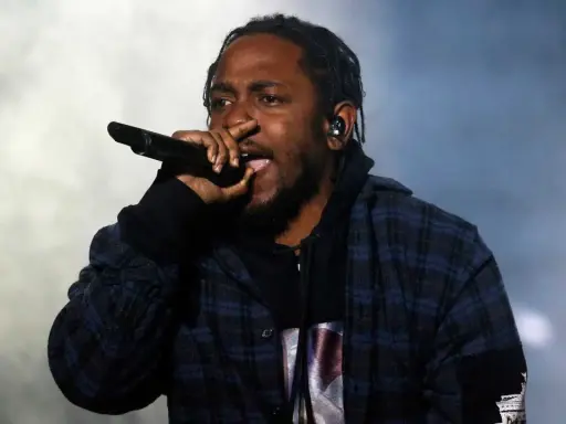 Kendrick Lamar, way out west, sjunger i en rutig skjorta med en mikrofon i handen.