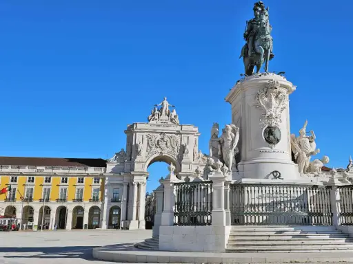 Reiterdenkmal und Triumphbogen am Praça do Comércio in **Baixa Lissabon** unter strahlend blauem Himmel.