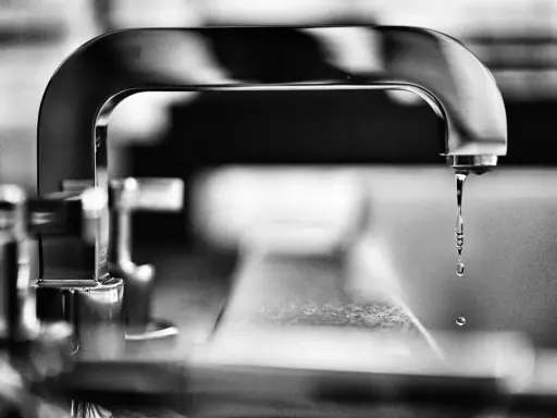 Gouttes d'eau tombant d'un robinet, évoquant la dureté de l'eau à Lyon.