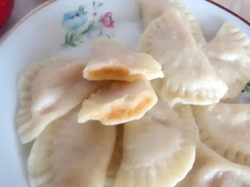 Pyszne pierogi z jabłkami, jeden rozkrojony ukazuje słodkie nadzienie.