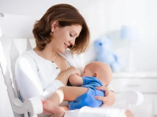 Mama karmi piersią dziecko na bujanym fotelu. Czy to powód, dlaczego dziecko ulewa?