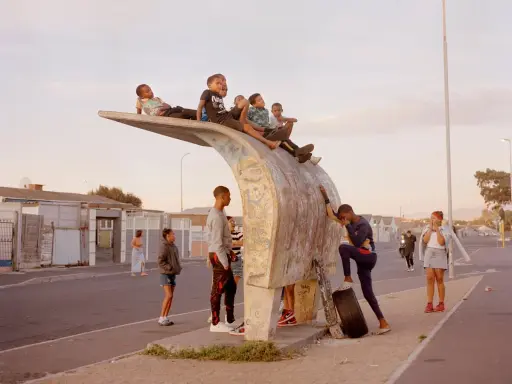 Kids gather on a unique bus stop structure, a scene that could be featured in a Belfast photo festival, capturing everyday life.
